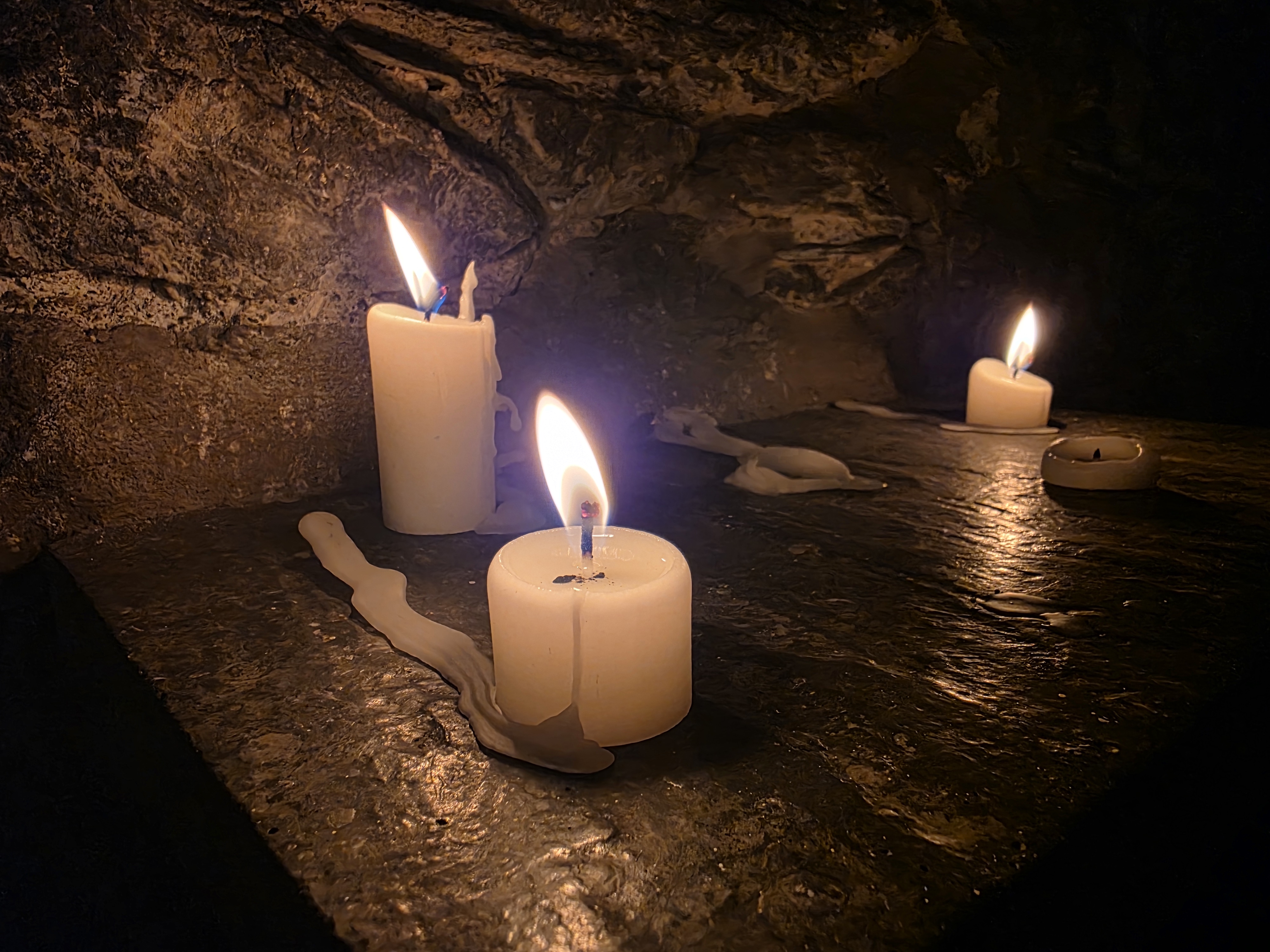 Candles burning in the stone chapel at Castlerigg